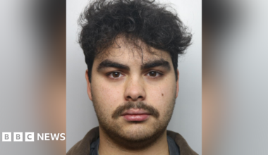 Kyran Smith mugshot. He has dark hair and dark stubble.