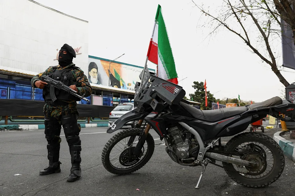 Majid Asgaripour/via Reuters - PHOTO: A member of a police force stands guard on a street in Tehran, Iran, on March 23, 2026.