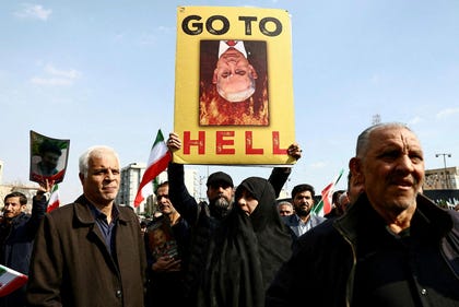 A person displays a sign depicting Israeli Prime Minister Benjamin Netanyahu as people gather for the funeral of Iranian security chief Ali Larijani and victims of the IRIS Dena warship at Enghelab Square, amid the U.S.-Israeli conflict with Iran, in Tehran, Iran, Wednesday.