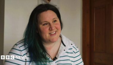 Dominique Shepherd, who has dark hair and dark eyes. She wears a white and green-striped rugby jersey.