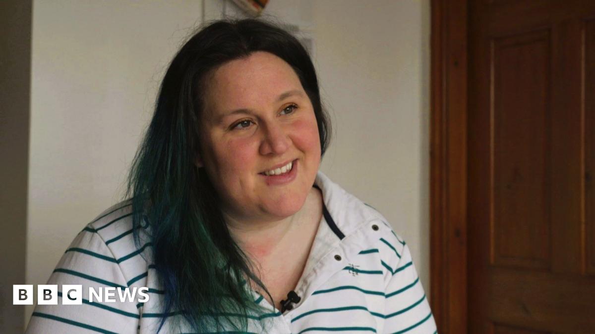 Dominique Shepherd, who has dark hair and dark eyes. She wears a white and green-striped rugby jersey.