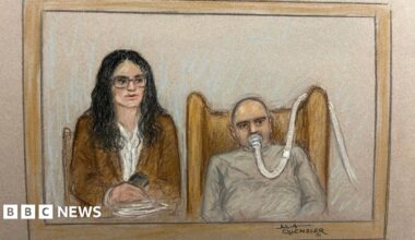 Salem Michel Al-Salem in a court sketch - he is on the right of the picture with a breathing tube on his mouth, a grey sweatshirt, he has a bald head and is slumped in an armchair. The tube makes his expression unclear. His translator, a woman with black shoulder length hair, a brown blazer, white shirt, and glasses, is sitting next to him
