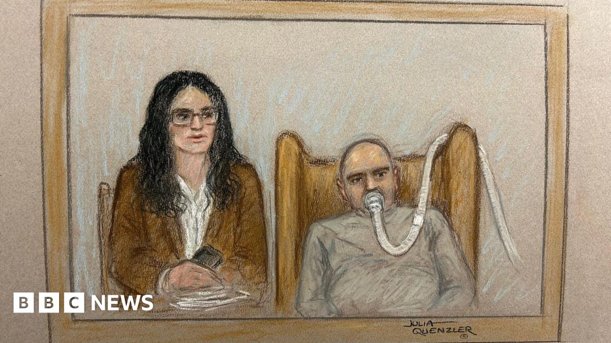 Salem Michel Al-Salem in a court sketch - he is on the right of the picture with a breathing tube on his mouth, a grey sweatshirt, he has a bald head and is slumped in an armchair. The tube makes his expression unclear. His translator, a woman with black shoulder length hair, a brown blazer, white shirt, and glasses, is sitting next to him