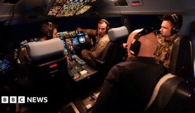 BBC correspondent Jonathan Beale is seen wearing a black shirt and headset in the cockpit of the Voyager. Two pilots, another crew member and the large control system can be seen in the background