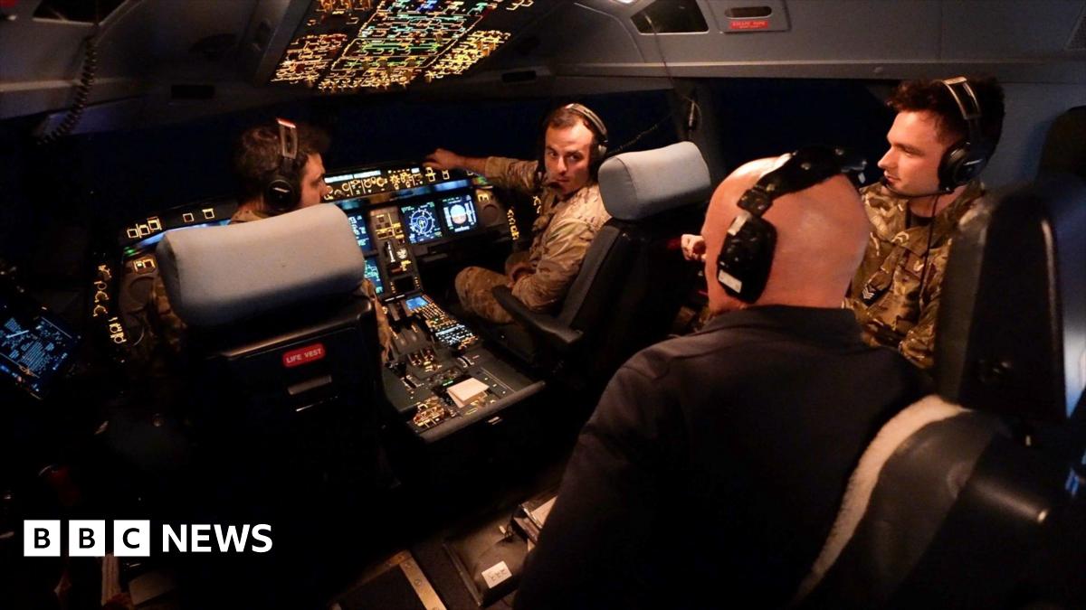 BBC correspondent Jonathan Beale is seen wearing a black shirt and headset in the cockpit of the Voyager. Two pilots, another crew member and the large control system can be seen in the background