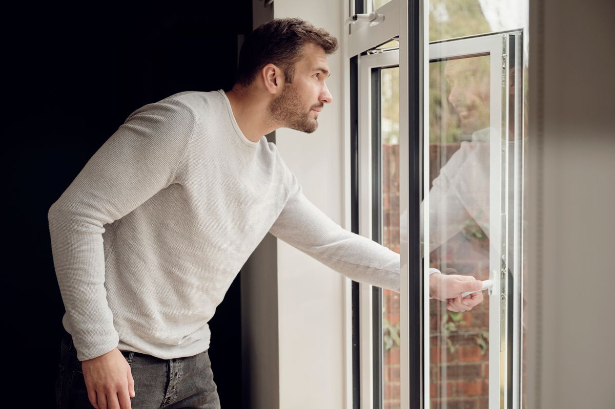 A man closing a window - stock image