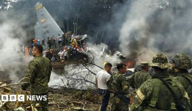 Soldiers and rescuers  are seen near an Air Force Hercules plane from which thick smoke is rising after the aircraft crashed during take-off in Puerto Leguizamo, Colombia(Photo by daniel ortiz / AFP via Getty Images)
