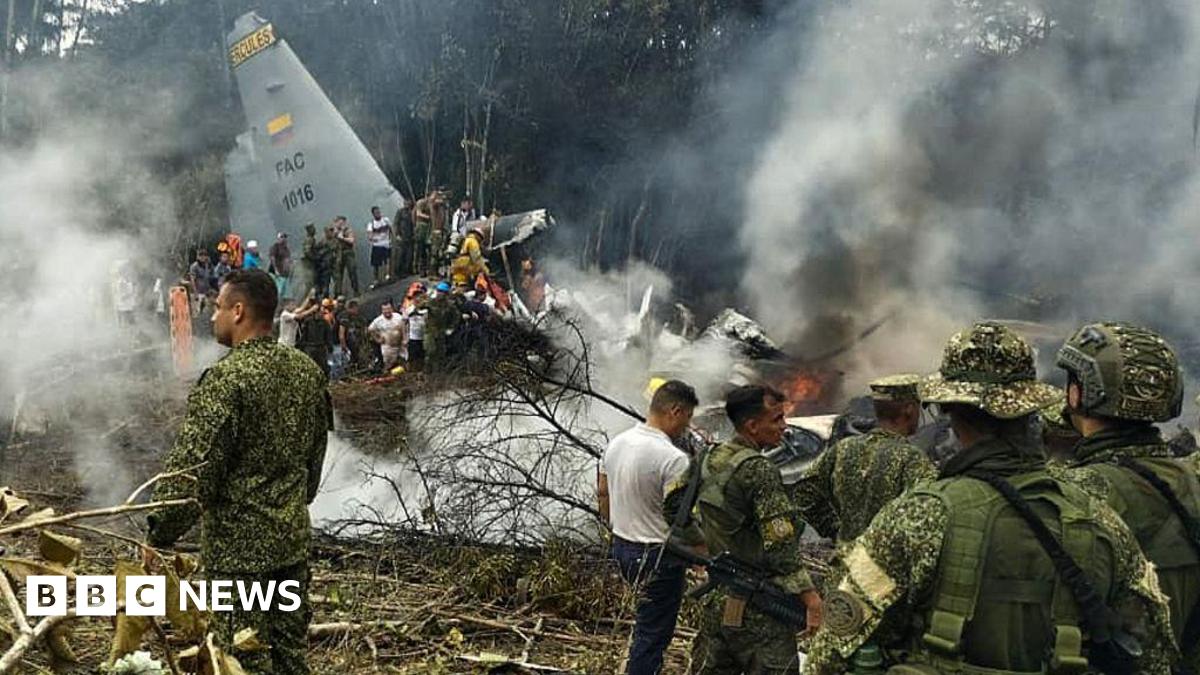 Soldiers and rescuers  are seen near an Air Force Hercules plane from which thick smoke is rising after the aircraft crashed during take-off in Puerto Leguizamo, Colombia(Photo by daniel ortiz / AFP via Getty Images)