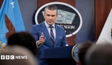 Smoke plumes billow from the site of airstrikes near Azadi Tower in western Tehran on 10 March. The night sky and smoke are black. Below, lights are on in buildings and a tower is lit up.
