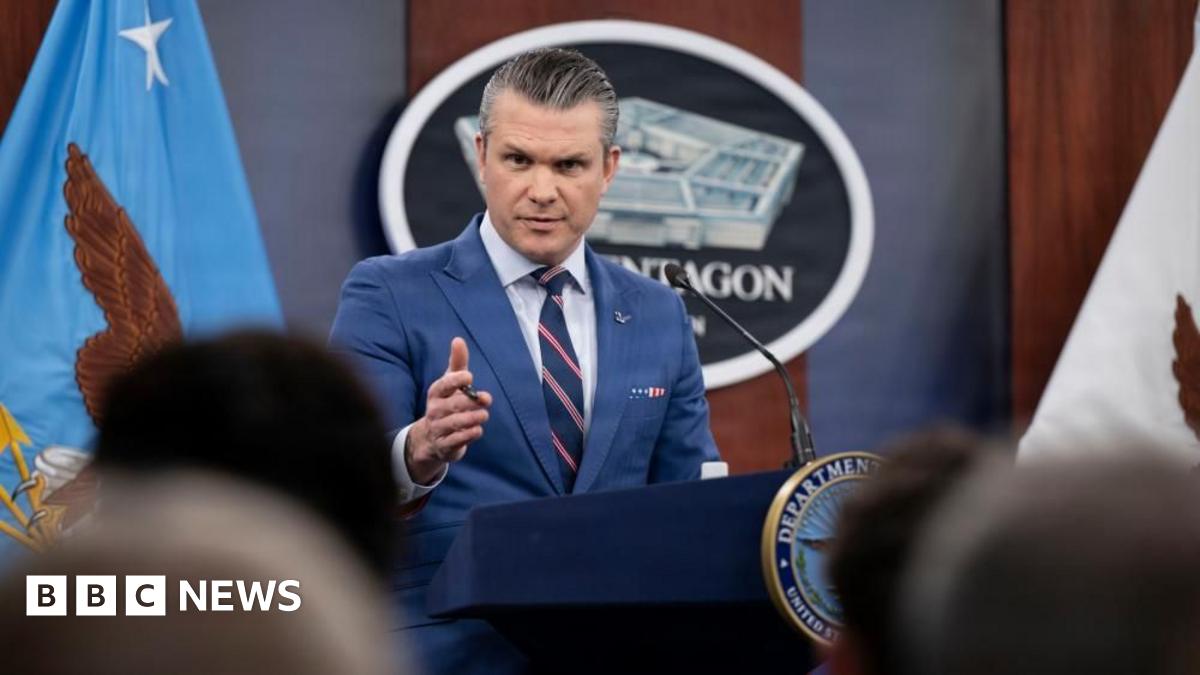 Smoke plumes billow from the site of airstrikes near Azadi Tower in western Tehran on 10 March. The night sky and smoke are black. Below, lights are on in buildings and a tower is lit up.