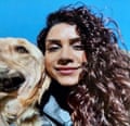 Paria Veisi smiling for the camera while holding a dog