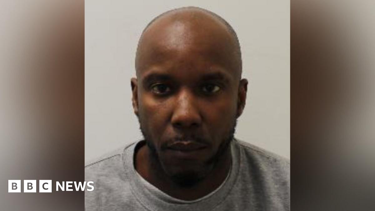 A mugshot of Owusu in a grey crewneck shirt. He stares blankly at the camera.