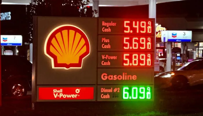 Gas station price sign at night showing regular gas at $5.49, plus $5.69, V-Power $5.89, and diesel $6.09