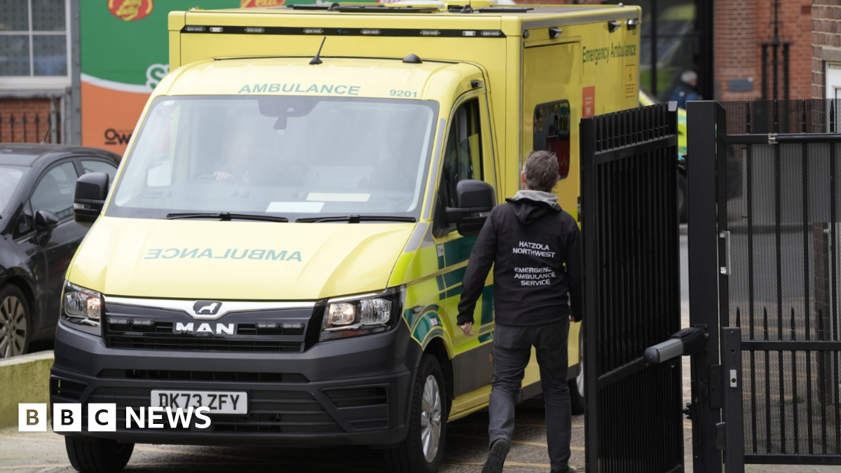 Three men in red emergency service worker uniforms survey damage from a strike on Tehran, Iran. Photo: 23 March 2026.
