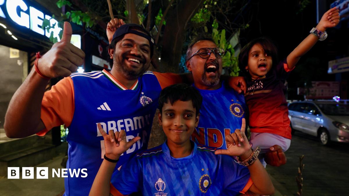 Two men and two children - of which three are wearing the blue jersey of the India men's cricket team - celebrate India's victory in the T20 cricket World Cup in the southern city of Bangalore on 8 March 2026.