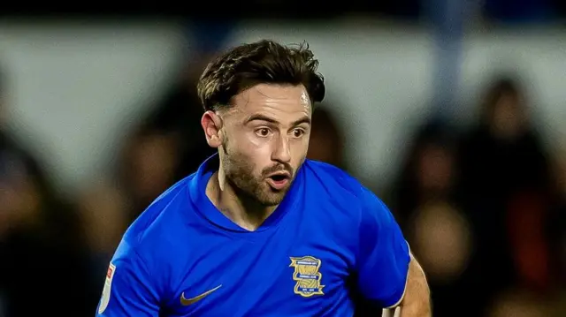 Birmingham winger Patrick Roberts with his mouth open looking up while running forward with the ball.