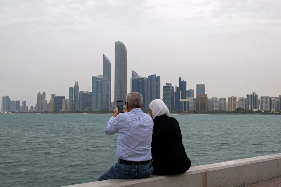 Ryan Lim/AFP via Getty Images - PHOTO: People sit along the corniche area in Abu Dhabi, UAE, on March 20, 2026.