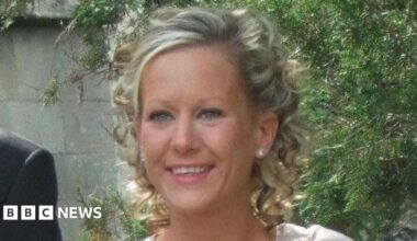 Gillian Morand stands outside in front of a tree. She has blonde curly hair.