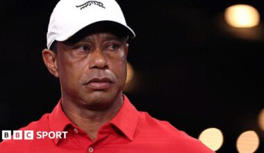 Tiger Woods in a red shirt and white cap