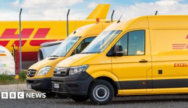 Two yellow DHL vans in front of a cargo plane parked on Leipzig Halle airport terminal