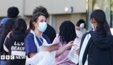 Students wait in line at the entrance to the sports hall at University of Kent campus in Canterbury for where the rollout of a meningitis B vaccine to about 5,000 students has begun