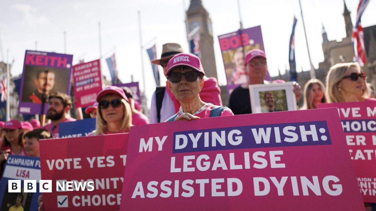 Campaigners outside the houses of Parliament hold pink placards reading "My dying wish: Legalise assisted dying".
