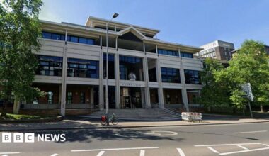 A street view of a court building. There are trees outside the building.