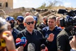 Israeli Prime Minister Benjamin (Bibi) Netanyahu, accompanied by Dimona Mayor, Benny Biton (L), speak to media while visiting the area destroyed by an Iranian ballistic missile last night, leaving over 50 wounded residents on March 22, 2026 in Dimona, Israel.