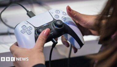 A woman's hands gripping a PlayStation 5 controller.