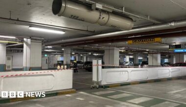 Scene of incident at Charlestown Shopping Centre underground car park in Finglas. There is red and white tape in the foreground as well as white walls. There is a yellow and black sign saying caution near the roof.