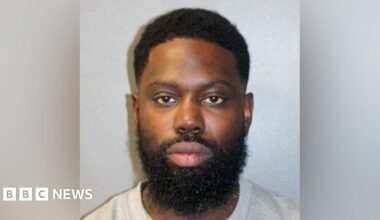 A custody image of Justin Clarke-Samuel in a grey T-shirt.