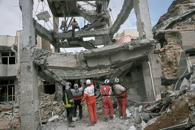 First responders inspect the remains of a residential building hit in an overnight strike during the U.S.-Israeli military campaign in Tabriz, northwestern Iran, on March 24.