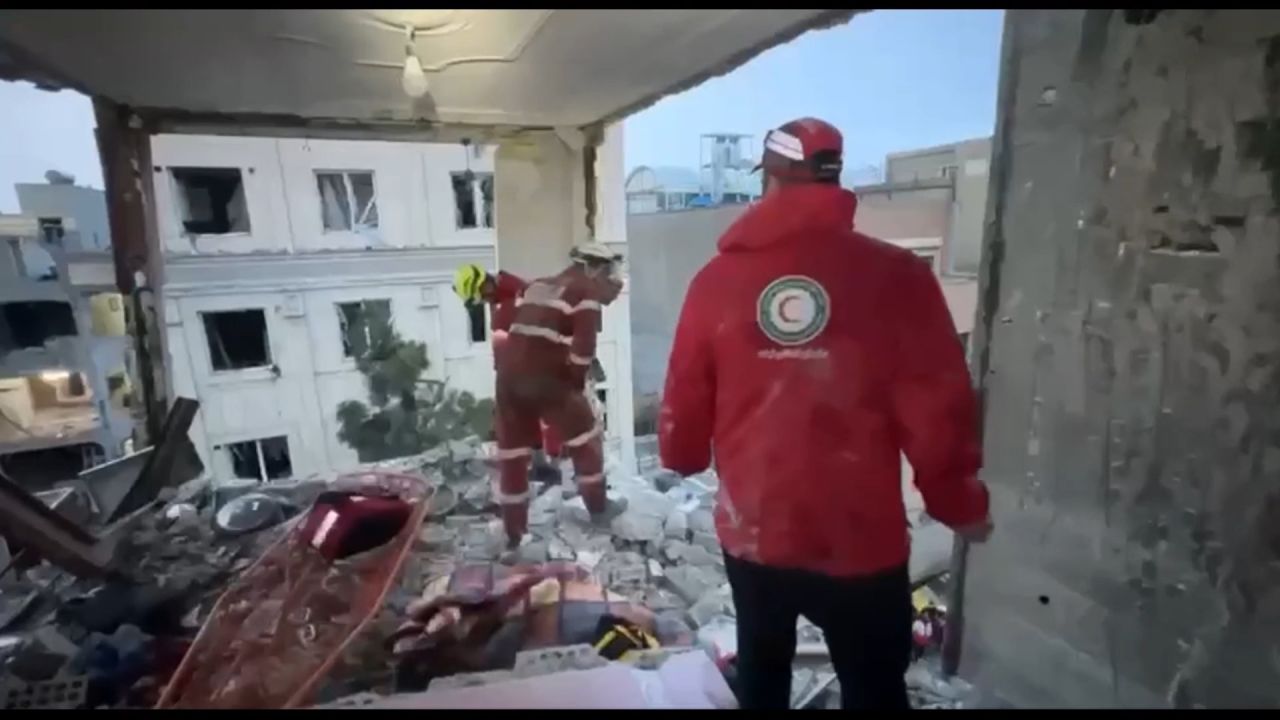 <p>Emergency responders searching a damaged building for survivors following overnight strikes on Tehran</p>