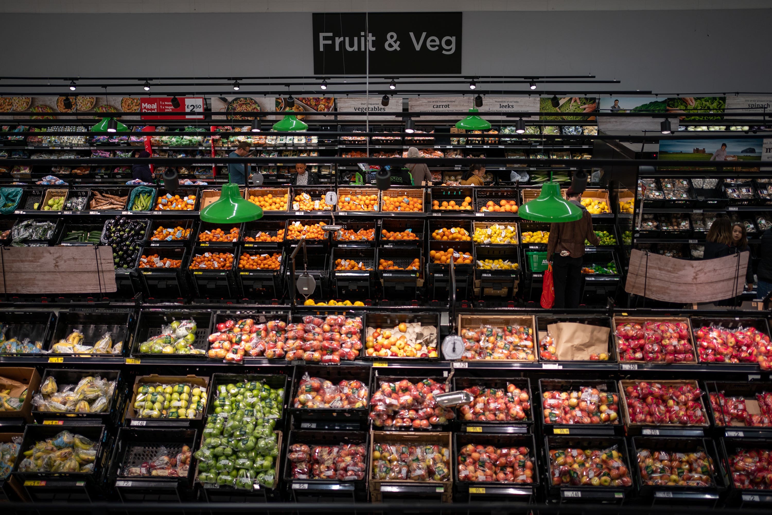 Shoppers in the fruit and vegetables section of Asda (PA)