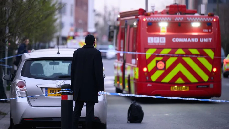 A man stands at the cordon as fire services continue to monitor the scene. - Leon Neal/Getty Images
