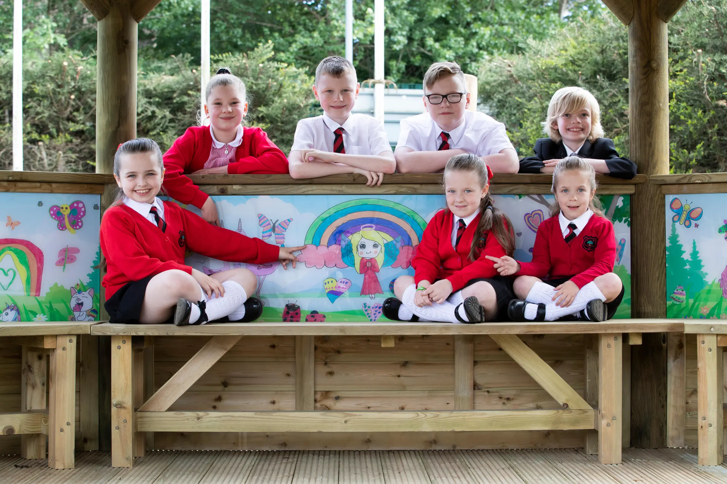 Pupils Chloe Adams, Aaron Reid, Kerr Reid, Felix Sneddon, Kacie, Isla, and Jorgia Cowie with artwork inside a play shelter.