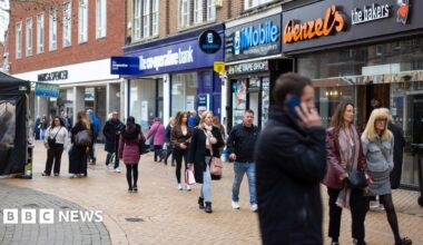 A scene of a high street in Chelmsford earlier this week shows people walking down the street and a man on his phone with shops lining the street.