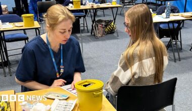 A student about to receive the Meningitis B vaccine at the University of Kent sports hall