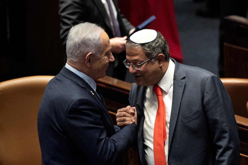 Benjamin Netanyahu and Itamar Ben Gvir shake hands on the floor of the Israeli parliament.