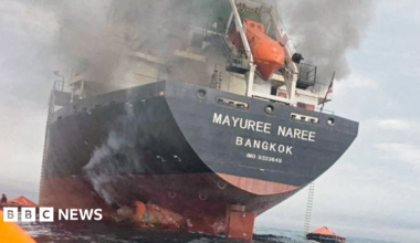 Smoke seen above a cargo ship with 'Bangkok' written on it