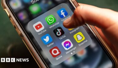 A phone screen showing several social media platforms with someone's finger hovering over TikTok icon