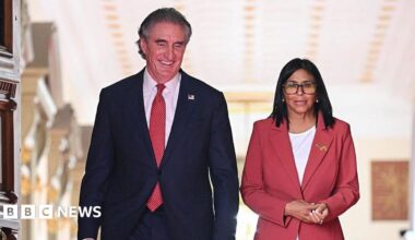 Venezuela's interim president, Delcy Rodriguez and US Interior Secretary Doug Burgum walk side by side