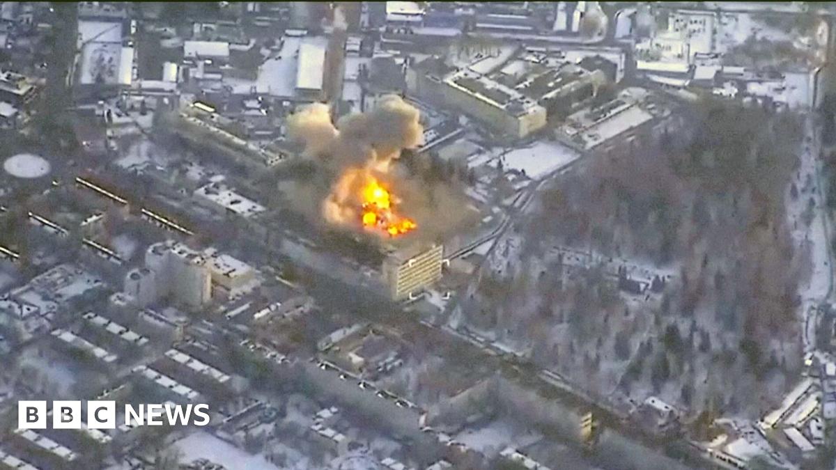 Fire and smoke rising from a building in the middle of built-up areas