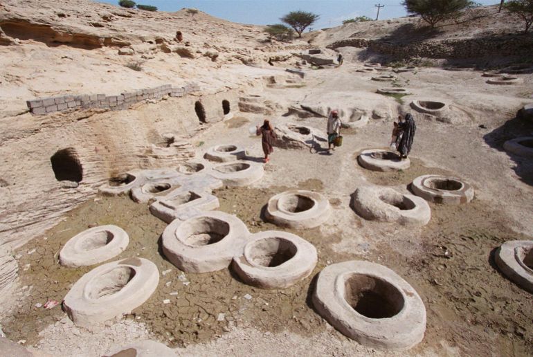 Iranians collect drinking water at the Tala (gold) wells in Laft village on Qeshm Island 17 February 2001. The area contains 366 wells, the number of days in a leap year, that were dug approximately 2,000 years ago. One hundred of the wells are still functioning. Qeshm Island, in southern Iran's Hormozgan province, is located 1,060 kilometres southeast of Tehran. (FILM) AFP PHOTO/Henghameh FAHIMI (Photo by HENGHAMEH FAHIMI / AFP)