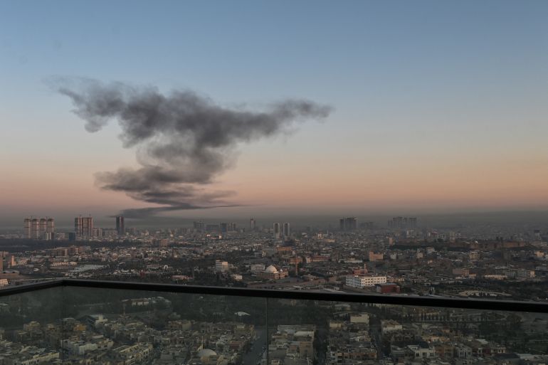 A plume of smoke rises near Erbil International Airport in Erbil on March 1, 2026. Loud explosions were heard early on March 1 near Erbil airport, which hosts US-led coalition troops in Iraq's autonomous Kurdistan region, an AFP journalist said. (Photo by Shvan HARKI / AFP)
