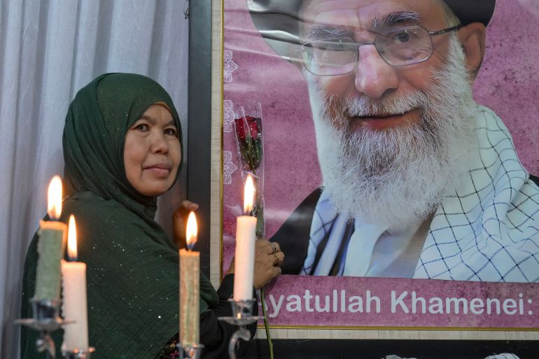 A mourner poses next to a portrait of Iranian supreme leader Ayatollah Ali Khamenei, who was killed amid US-Israel strikes, during the signing of a petition committing to international justice values, held at the Iranian Ambassador's residence in Jakarta on March 5, 2026. (Photo by BAY ISMOYO / AFP)