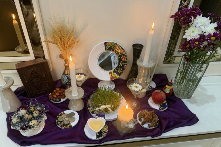 A candle burns on a Haft-Sin table, an arrangement of seven symbolic items which names start with the letter "S", to celebrate the spring holiday of Nowruz