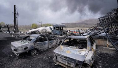 Burned vehicles sit near an oil storage facility struck by a U.S.-Israeli attack late Saturday as a thick plume of smoke rises in Tehran, Iran, Sunday, March 8, 2026. (Vahid Salemi/AP)