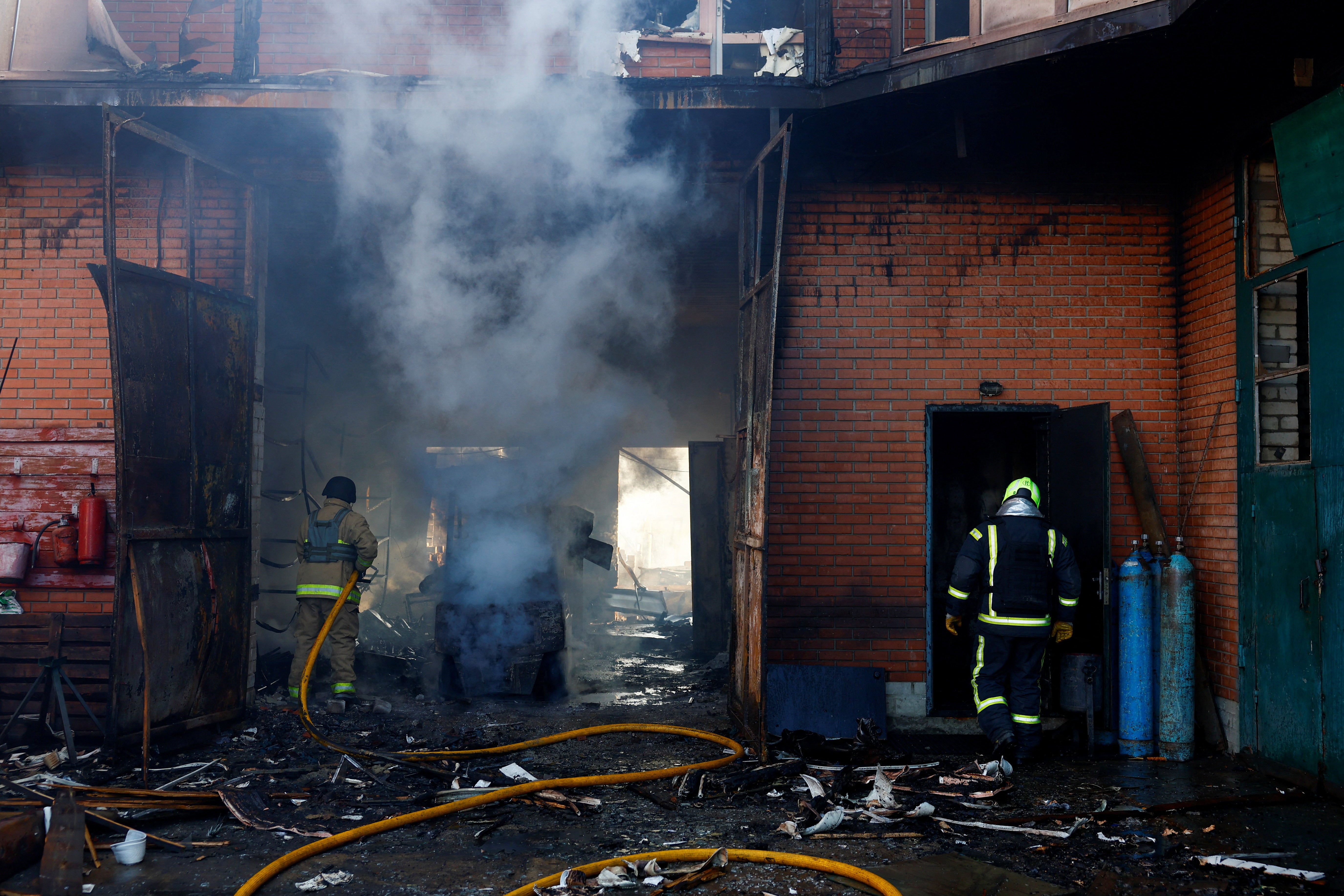 Firefighters work at a warehouse and production facility at the site of a Russian missile and drone strike, amid Russia's attack on Ukraine, in the town of Brovary, Kyiv region