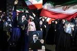 People wave national flags and hold portraits of Iran's supreme leader Mojtaba Khamenei as they march in support of the Iranian armed forces in central Tehran on March 25, 2026.
